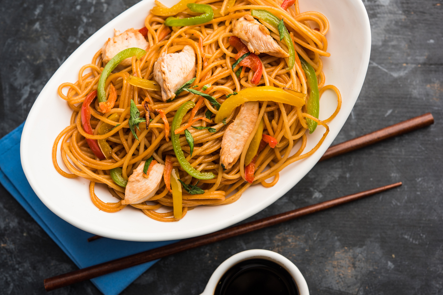 Chicken Hakka/Schezwan noodles served in a bowl with chopsticks. selective focus